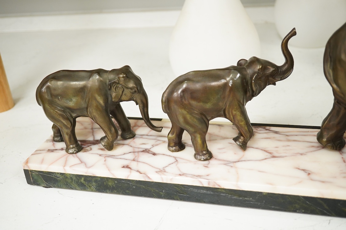 An Art Deco study, three spelter elephants, raised on marble and onyx base, 54cm wide